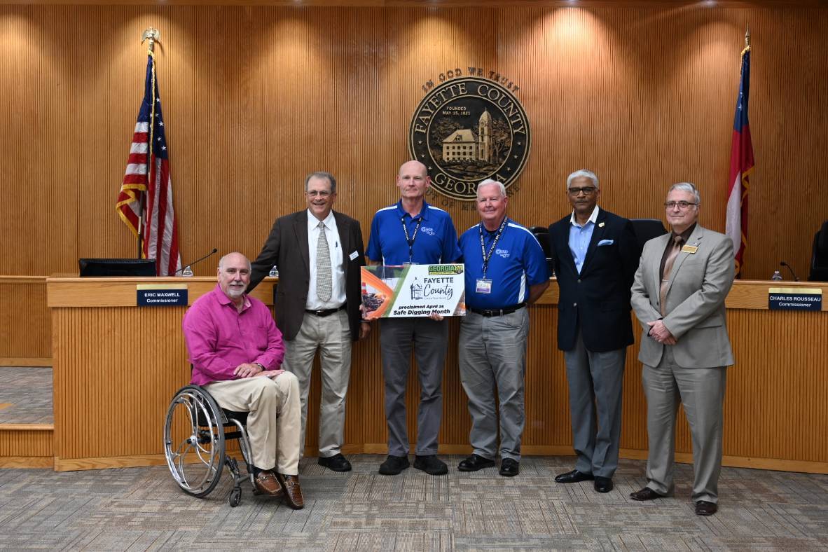 Board of commissioners and county employees holding signs